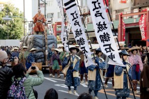 kids pulling a float representing a construction stone with a man on top