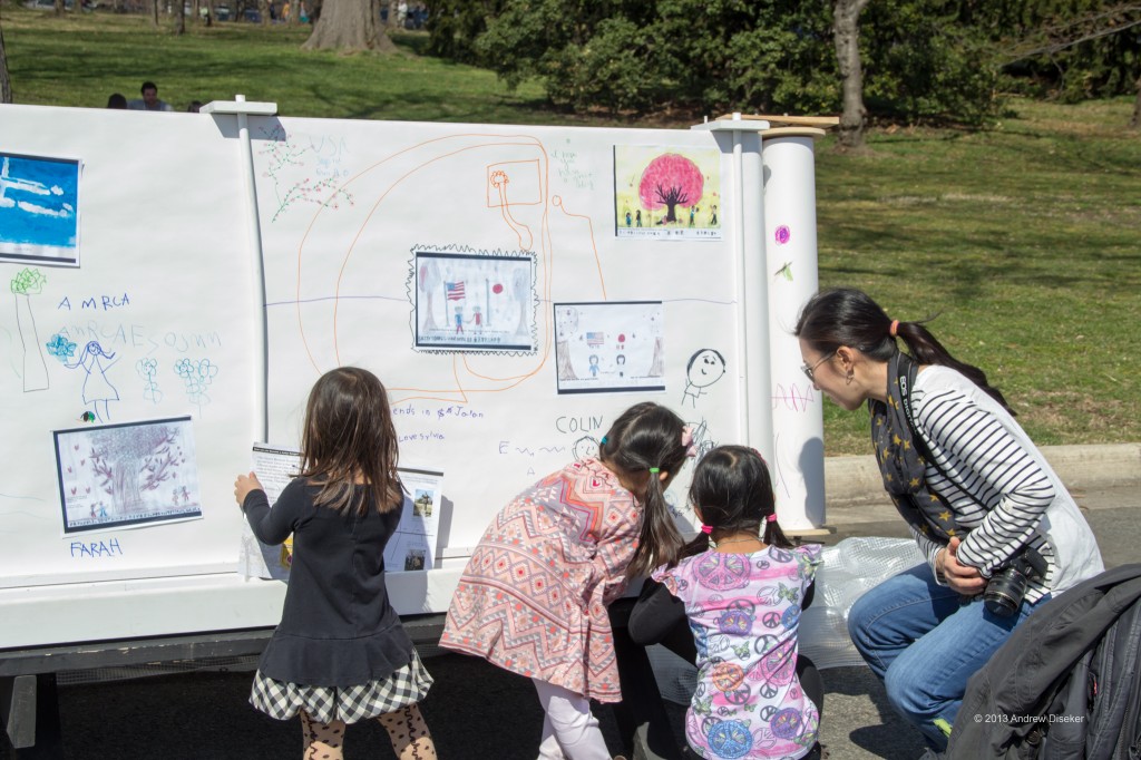 three little girls and their mother(?) drawing on the mural